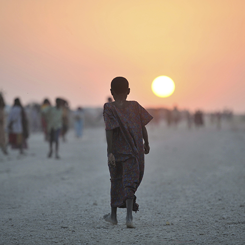 A Somali girl walks down a road at sunset in an IDP camp near the town of Jowhar.
