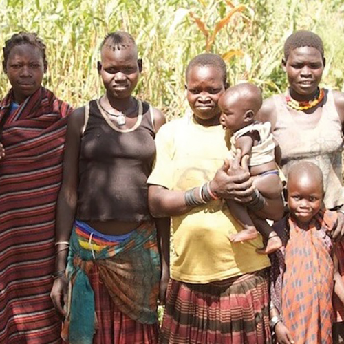 women and children standing by a field in Uganda
