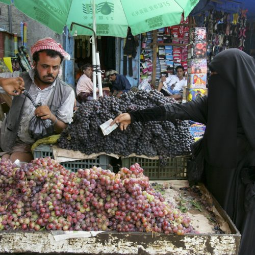 A woman shops for food in an outdoor market in Taiz, Yemen